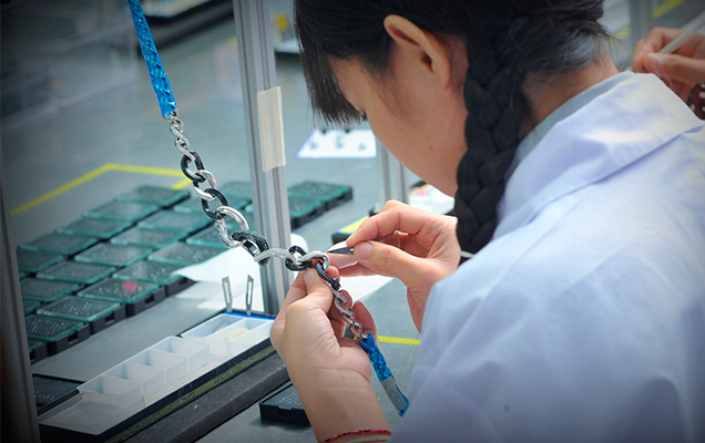 Woman placing crystals in necklace by hand