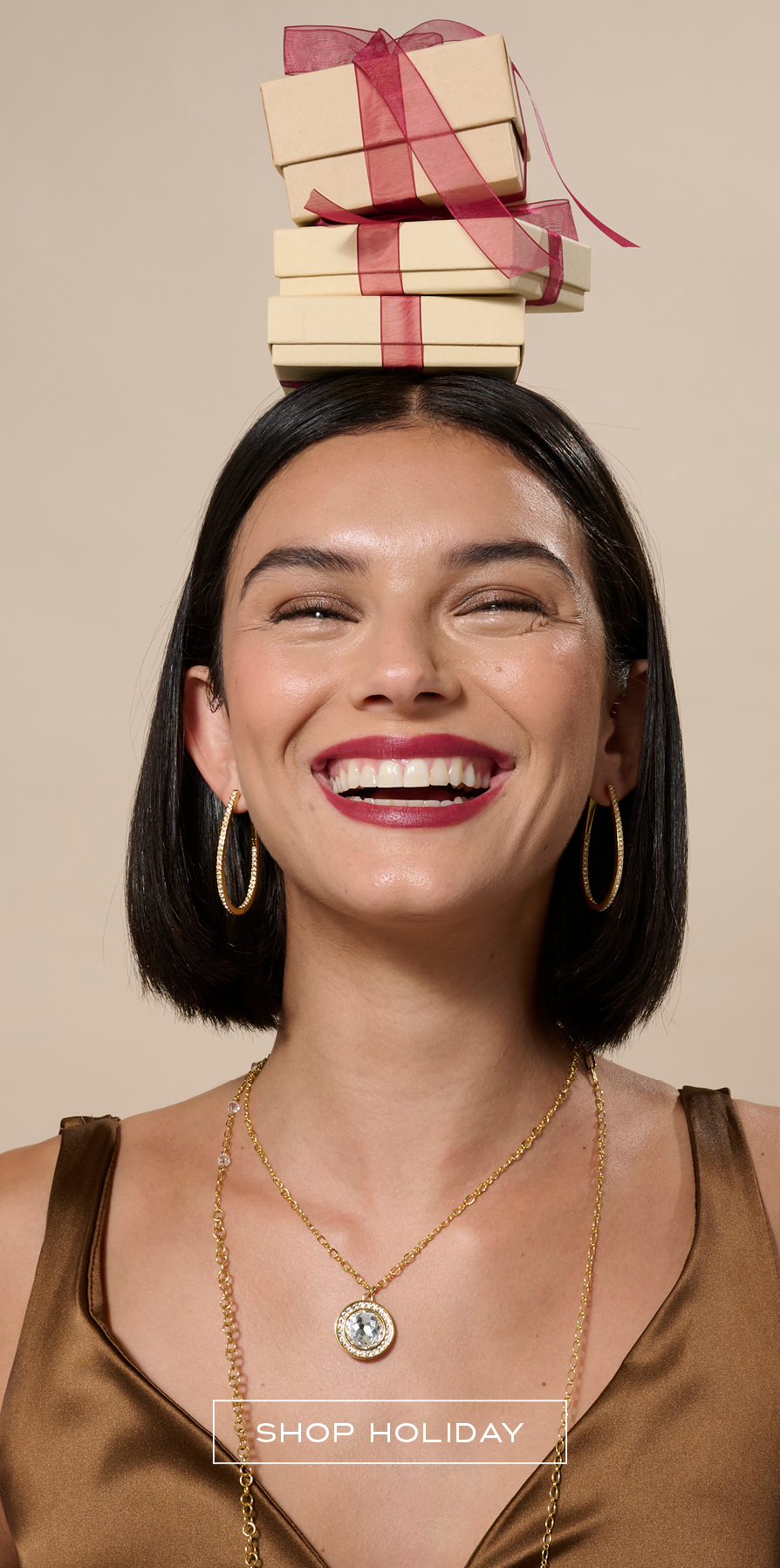 Woman holding holiday jewelry gifts wearing golden jewelry